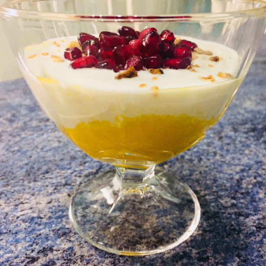 Mango-Joghurt-Dessert mit Kokos-Granola-Topping und Granatapfelkernen ...
