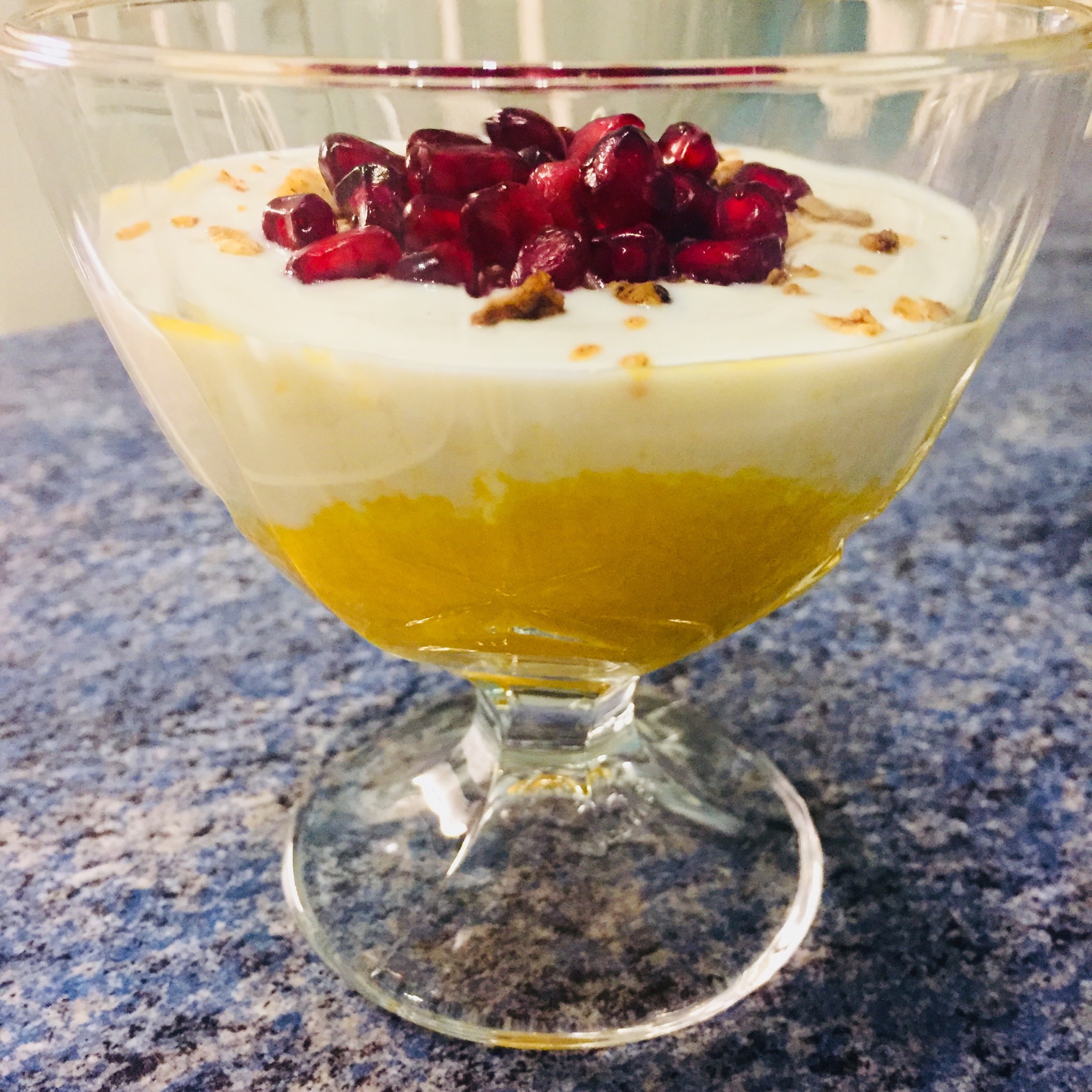 Mango-Joghurt-Dessert mit Kokos-Granola-Topping und Granatapfelkernen ...
